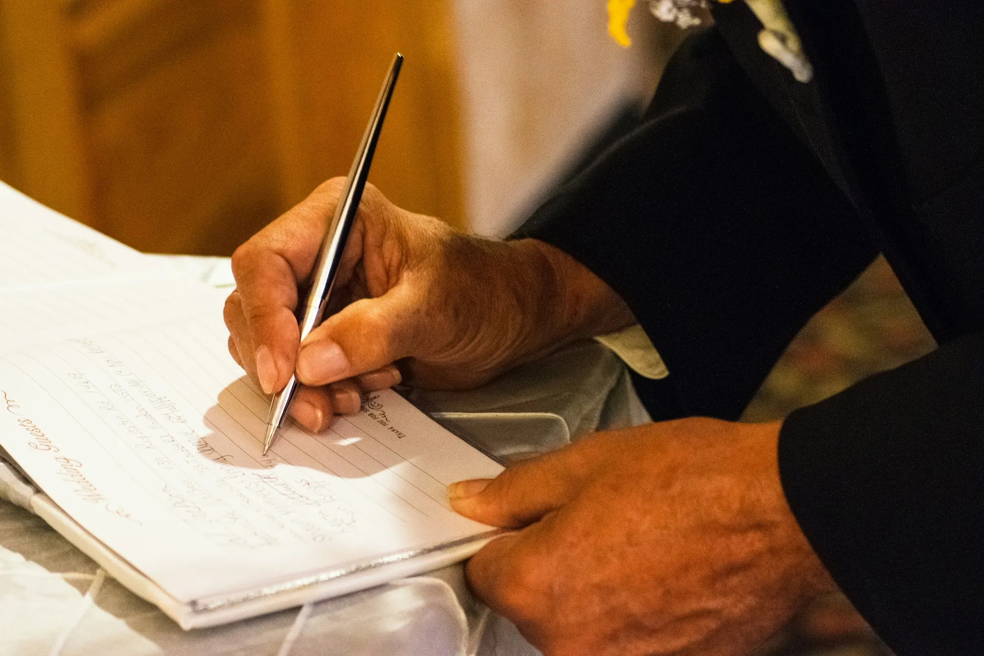 Hand signing a document with a pen