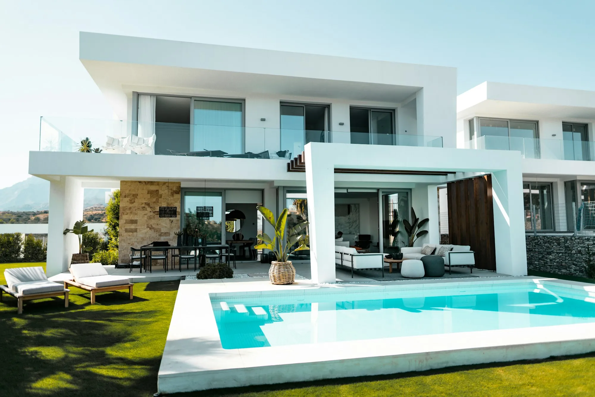 Modern white two-story house with a backyard swimming pool